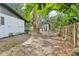 Spacious backyard showcasing mature trees, a wooden fence, and the property's exterior at 1332 Marjohn Ave, Clearwater, FL 33756