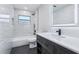 Modern bathroom with a gray vanity, illuminated mirror, and tiled tub and shower at 1332 Marjohn Ave, Clearwater, FL 33756