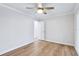A brightly lit bedroom with wood floors, a ceiling fan, and a door leading to another room at 1332 Marjohn Ave, Clearwater, FL 33756