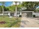 Beautiful home boasts an attached two car garage, manicured lawn, and lovely landscaping at 1332 Marjohn Ave, Clearwater, FL 33756