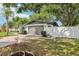 This property features an attached two car garage, a manicured lawn, and a white fence at 1332 Marjohn Ave, Clearwater, FL 33756