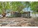 Rear exterior showcasing a screened-in porch and a spacious yard with mature trees at 1332 Marjohn Ave, Clearwater, FL 33756