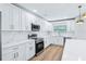 Updated kitchen featuring white cabinets, stainless steel appliances, and sleek marble countertops and backsplash at 1332 Marjohn Ave, Clearwater, FL 33756