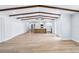 Bright and airy living room with wood-look flooring and rustic ceiling beams, flowing into the modern kitchen at 1332 Marjohn Ave, Clearwater, FL 33756