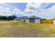Expansive backyard featuring a detached garage, wooden fence, and lush green space, perfect for outdoor enjoyment at 13338 Jaudon Ranch Rd, Dover, FL 33527