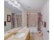 Bathroom featuring granite counters and shower with decorative tile at 13338 Jaudon Ranch Rd, Dover, FL 33527