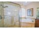 Luxurious bathroom with glass enclosed shower and soaking tub with tile surround at 13338 Jaudon Ranch Rd, Dover, FL 33527