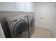 Laundry room with white cabinets and stainless front-loading washer and dryer at 13338 Jaudon Ranch Rd, Dover, FL 33527