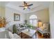 Cozy living room with hardwood floors, plantation shutters, tray ceiling with ceiling fan, and comfortable seating at 13338 Jaudon Ranch Rd, Dover, FL 33527