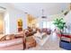 Spacious living room with tile floors, leather furniture, ceiling fan, and open access to the dining and kitchen areas at 13338 Jaudon Ranch Rd, Dover, FL 33527