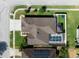 Stunning aerial view of a home featuring a screened-in pool, trampoline, and well-maintained landscaping at 1447 Stetson Dr, Wesley Chapel, FL 33543