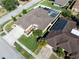 This aerial view of the property highlights solar panels, the screened in pool and a fully fenced backyard at 1447 Stetson Dr, Wesley Chapel, FL 33543