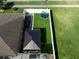 An aerial view of the property featuring a gazebo, playground, a fenced yard, solar panels and a screened in pool at 1447 Stetson Dr, Wesley Chapel, FL 33543