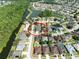 Aerial view of the home's location within a lovely community with mature trees near a pond and a conservation area at 1447 Stetson Dr, Wesley Chapel, FL 33543
