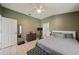 Serene bedroom with green walls, neutral furnishings, and exercise equipment for a convenient workout space at 1447 Stetson Dr, Wesley Chapel, FL 33543