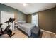 Cozy bedroom featuring a comfortable bed, tufted bench, and an exercise bike in the corner at 1447 Stetson Dr, Wesley Chapel, FL 33543