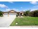 Charming single-story home boasts a three-car garage, well-manicured lawn, and inviting curb appeal at 1447 Stetson Dr, Wesley Chapel, FL 33543