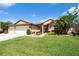Charming single-Gathering home featuring a well-manicured lawn, a three-car garage, and mature landscaping at 1447 Stetson Dr, Wesley Chapel, FL 33543