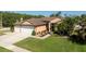 Charming single-Gathering home featuring a well-manicured lawn, a three-car garage, and beautiful landscaping at 1447 Stetson Dr, Wesley Chapel, FL 33543