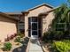 Inviting front exterior featuring a screened porch, lush landscaping, and a well-maintained walkway at 1447 Stetson Dr, Wesley Chapel, FL 33543