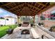Outdoor gazebo with a fire pit, lush foliage, and cozy seating, perfect for entertaining and relaxation at 1447 Stetson Dr, Wesley Chapel, FL 33543