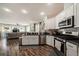 Modern kitchen features stainless steel appliances, white cabinets, and an open view to the living room at 1447 Stetson Dr, Wesley Chapel, FL 33543