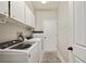 Functional laundry room featuring white cabinets, modern appliances, and a neutral color scheme at 1447 Stetson Dr, Wesley Chapel, FL 33543