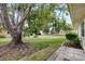 Large backyard with lush grass, mature trees, and an outdoor patio at 1530 Ingram Dr # 1530, Sun City Center, FL 33573