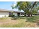 Backyard with lush lawn, mature trees, and landscaping at 1530 Ingram Dr # 1530, Sun City Center, FL 33573