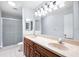 Double vanity bathroom with large mirror, a shower, and updated fixtures at 1530 Ingram Dr # 1530, Sun City Center, FL 33573