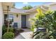 Inviting front entrance with a blue door, lush landscaping, and a cozy chair, creating a welcoming ambiance at 1530 Ingram Dr # 1530, Sun City Center, FL 33573