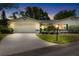 Lovely home with glowing lights, a garage, and a driveway, surrounded by lush greenery and trees at 1530 Ingram Dr # 1530, Sun City Center, FL 33573