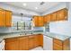 Functional kitchen featuring wooden cabinetry, a stainless steel sink, and a bright window overlooking the yard at 1530 Ingram Dr # 1530, Sun City Center, FL 33573