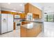 Well-equipped kitchen with wooden cabinets, white appliances, and ample counter space for meal preparation at 1530 Ingram Dr # 1530, Sun City Center, FL 33573