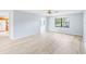 Spacious living room with light wood floors, a ceiling fan, and natural light from a large window at 1530 Ingram Dr # 1530, Sun City Center, FL 33573