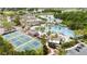Aerial view of community pool, tennis courts, and surrounding amenities including lush landscaping and golf cart parking at 1530 Ingram Dr # 1530, Sun City Center, FL 33573