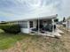 A covered back porch area with outdoor furniture and a small grill at 1542 Derrick St, Holiday, FL 34690