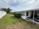 Spacious backyard featuring a well-maintained lawn, mature hedges, and a covered patio area, ideal for outdoor enjoyment at 1542 Derrick St, Holiday, FL 34690