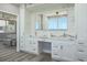 Bathroom featuring double sinks, marble countertops, and views of ocean from vanity at 1600 Gulf Blvd # 1112, Clearwater Beach, FL 33767
