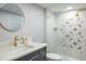 Bathroom with a modern vanity, round mirror, and patterned glass shower screen with gold hardware at 1600 Gulf Blvd # 1112, Clearwater Beach, FL 33767