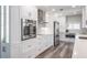Modern kitchen with stainless steel appliances, white cabinets, and beautiful wood floors at 1600 Gulf Blvd # 1112, Clearwater Beach, FL 33767