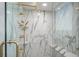Elegant shower features marble tile, a built-in bench, and gold hardware for a luxurious experience at 1600 Gulf Blvd # 1112, Clearwater Beach, FL 33767