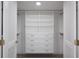 Organized walk-in closet featuring white built-in shelves, drawers, and gold hardware at 1600 Gulf Blvd # 1112, Clearwater Beach, FL 33767