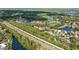 An aerial view shows a well-maintained neighborhood with mature trees near a highway and waterways at 18631 Le Dauphine Pl, Lutz, FL 33558