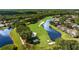 Scenic aerial view of a golf course community with lush landscaping and waterfront homes on a sunny day at 18631 Le Dauphine Pl, Lutz, FL 33558