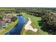 Aerial view showcasing homes alongside a beautiful golf course with a water feature and well-maintained landscapes at 18631 Le Dauphine Pl, Lutz, FL 33558