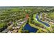 An aerial shot of homes situated along a beautiful lake and golf course, surrounded by mature trees and lush greenery at 18631 Le Dauphine Pl, Lutz, FL 33558