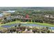 An aerial view displays a beautiful neighborhood alongside a golf course, pond, and mature trees at 18631 Le Dauphine Pl, Lutz, FL 33558