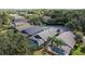 An aerial view of the rear of several homes with screen enclosed pools surrounded by lush trees and landscaping at 18631 Le Dauphine Pl, Lutz, FL 33558