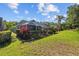 Lush backyard featuring a screened lanai, tropical landscaping and manicured lawn at 18631 Le Dauphine Pl, Lutz, FL 33558